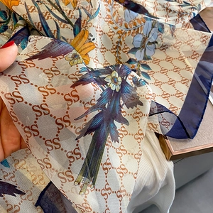 Close-up of lightweight floral scarf with sheer chiffon fabric and elegant patterns