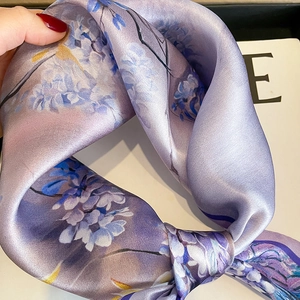 Close-up of purple floral silk scarf showing elegant satin texture and lilac patterns