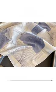 Detail of premium silk scarf showing refined rolled edge stitching and geometric pattern