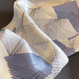 Elegant silk scarf with purple geometric patterns and a premium satin finish texture
