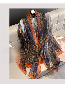Detailed view of lightweight cashew paisley scarf with floral patterns on a sofa
