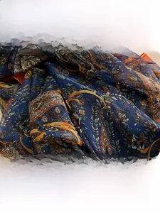 Detailed macro view of the intricate paisley pattern and silky fabric texture on this scarf