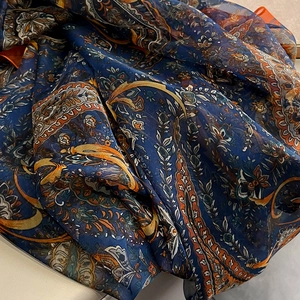 Detailed macro view of lightweight bohemian paisley print scarf with translucent texture
