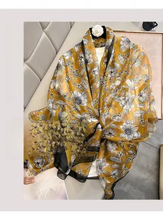 Detail of yellow floral chiffon scarf showing elegant botanical prints and sheer texture