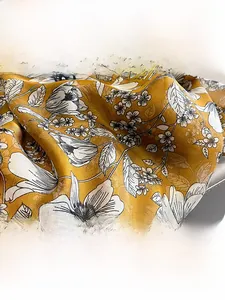 Detailed view of yellow floral silk scarf fabric with elegant soft drape and smooth texture