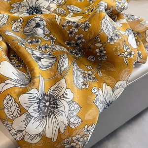 Detail of yellow silk scarf with elegant black and white floral sketch print patterns