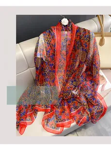 Detail of red floral chiffon beach shawl with blue and yellow abstract patterns