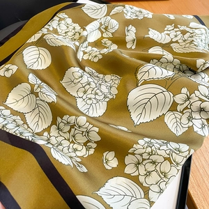 Detailed view of elegant floral silk scarf with smooth satin texture and flower pattern
