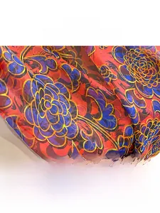 Close-up of lightweight chiffon fabric with vibrant red and blue floral patterns