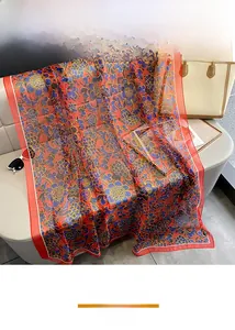 Detailed botanical print on a soft red silk scarf with blue and yellow floral patterns