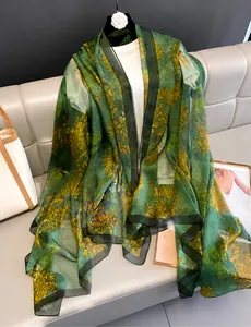 Detail of emerald green silk shawl with golden chrysanthemum and cloud patterns