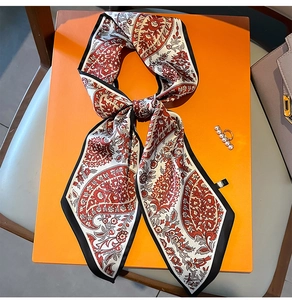 Detail eines Seidenschals mit Paisley-Muster und glattem Satin-Finish auf Geschenkbox