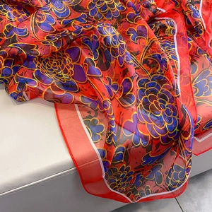 Macro shot of red floral print scarf showing lightweight texture and fine rolled edges