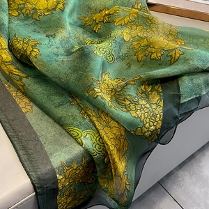 Detail of vintage floral silk scarf with large yellow peonies on dark green fabric