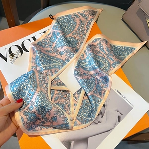 Detail eines rosa-blauen Paisley-Seidenschals auf einer luxuriösen Geschenkbox