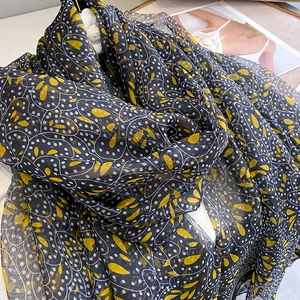 Detailed texture of black floral scarf with yellow droplet prints and white dots