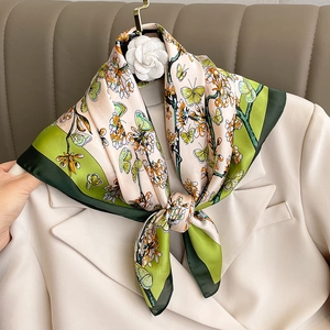 Foulard élégant en soie à fleurs et papillons sur un blazer beige et un cintre doré
