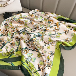 Écharpe florale aspect soie avec bordure verte et motif papillon sur fond en cuir