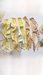 Flat lay of vintage floral and leopard print faux silk twilly scarves with a blazer