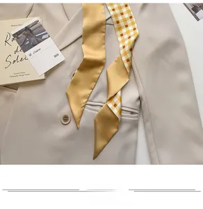 Detail of floral skinny scarf paired with a beige blazer for a French chic fashion look