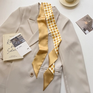 Detail of double-sided twilly scarf featuring floral pattern and script on a blazer