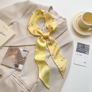 Elegant floral print yellow silk scarf styled on a beige blazer for a French chic look