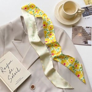 Floral yellow and cream silk skinny scarf twilly draped on a beige blazer stylish flat lay