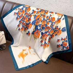Detailed texture of white silk scarf with orange flowers, blue leaves, and yellow cat pattern