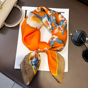 Elegant orange silk-like scarf with white camellia flowers and blue leaf prints