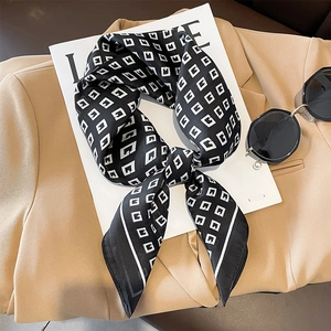 Fashionable black and white G-pattern silk square scarf styled on a beige suit