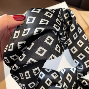 Detail of silk satin scarf featuring a black and white geometric G letter pattern