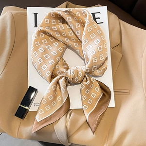 Elegant geometric pattern silk scarf in champagne and brown, styled on a chic blazer