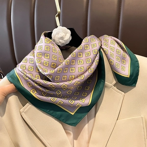 Silk scarf with yellow geometric patterns on lavender base styled on a beige blazer neck