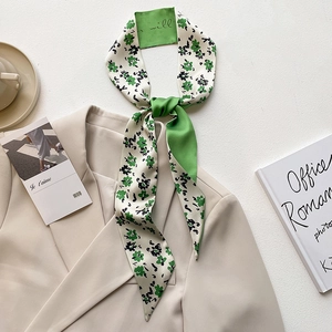 French style green floral skinny scarf tied on a beige blazer with elegant silk texture