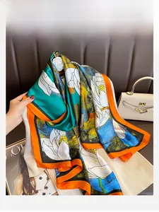 Detailed shot of vibrant lotus print silk scarf styled on a luxury leather surface