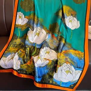 Silk scarf with white lotus print on lake green background and orange border detail