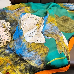 Detailed view of large silk scarf featuring floral lotus prints and soft twill texture
