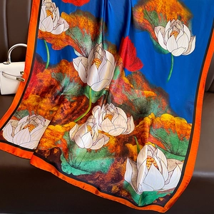 Oversized printed silk scarf with artistic lotus design and vibrant orange hem for women