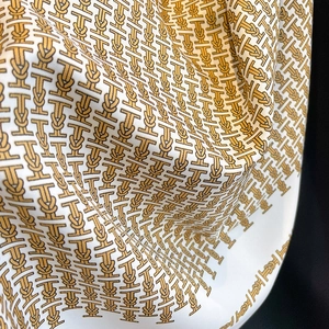 Close-up of elegant silk scarf with nautical rope patterns and glossy fabric texture