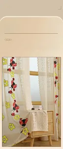 Detail of beige lace curtain with red ladybug and yellow flower floral embroidery