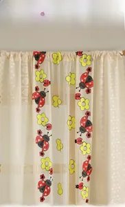 Close-up of beige lace curtains with butterfly and floral embroidery in rustic style