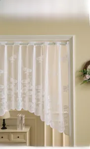 Detail of white daisy lace cafe curtain featuring intricate floral embroidery and wavy edge