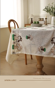 Detail of floral and mushroom embroidery on cream lace tablecloth with mesh texture
