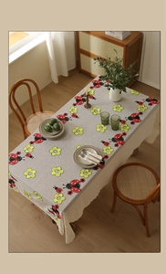 Detail of ladybug and flower embroidery with lace edges on the american style tablecloth