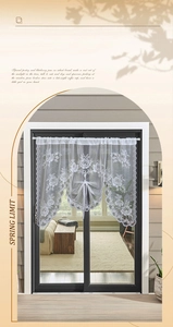 Detailed close-up of white lace curtain featuring rose embroidery and scalloped edges