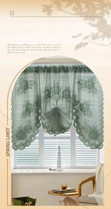 Detail of green lace curtain featuring floral embroidery and elegant scalloped edges