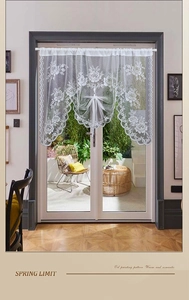 Detail of white lace coffee curtain with rose embroidery and elegant wavy hem design