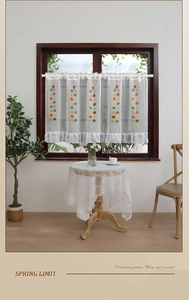 Detail of leaf embroidery and ruffle hem on semi-transparent linen textured cafe curtains