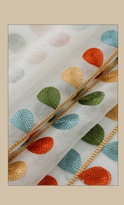 Detailed close-up of colorful leaf embroidery on semi-transparent linen cafe curtains