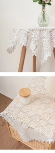 Close-up of white lace dust cover with crochet floral patterns and scalloped edges